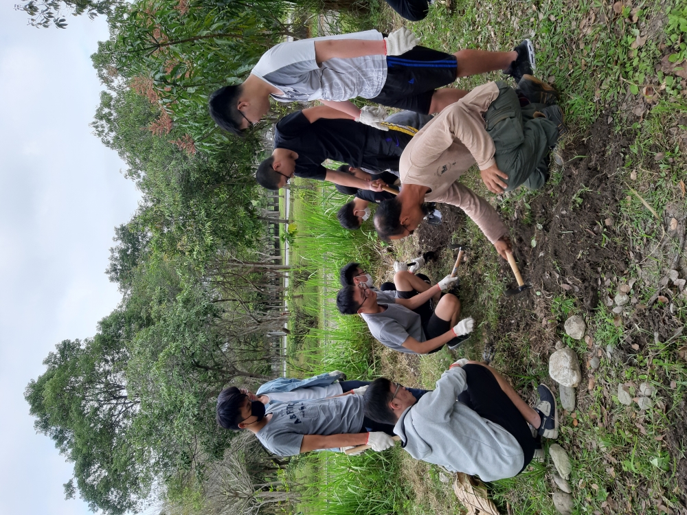 「校園永續生活設計」顏嘉成老師（右前蹲者）引導同學探索人與土地之間的關係、永續發展的實踐能力。
