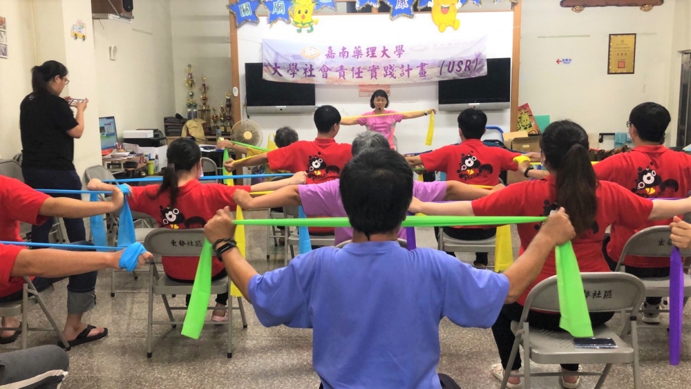 林秀碧老師與學生帶領長輩一起做彈力帶運動伸展肌肉。
(位置在第二段)