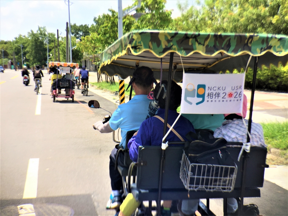 退休人員騎乘四人協力車至水雉保護園區參訪，年輕人在一旁協助交通狀況與車況