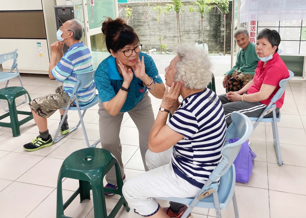 退休人員王春美指導仁愛社區居民進行健口體操，可幫助長者用餐前分泌適量唾液幫助消化維持口腔健康，進而提升大腦認知功能